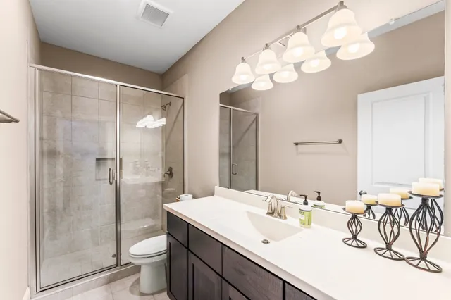 a bathroom with a double vanity sink mirror and toilet