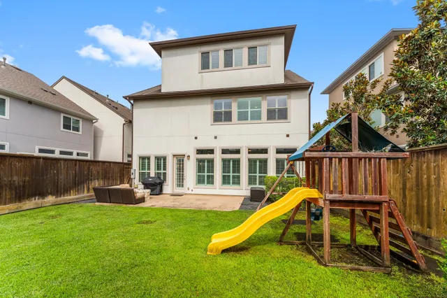 a view of a house with a backyard and a slide