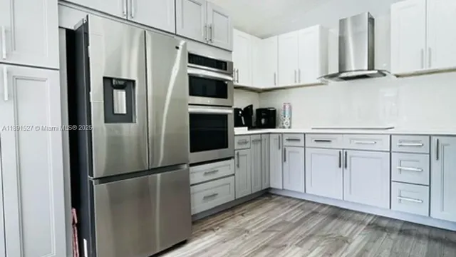 a kitchen with white cabinets and stainless steel appliances
