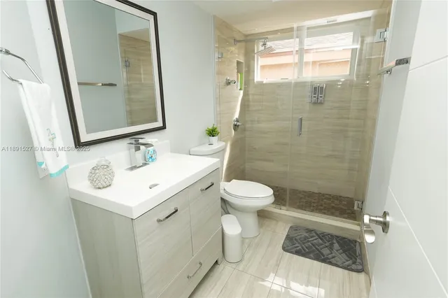 a bathroom with a sink mirror toilet and shower