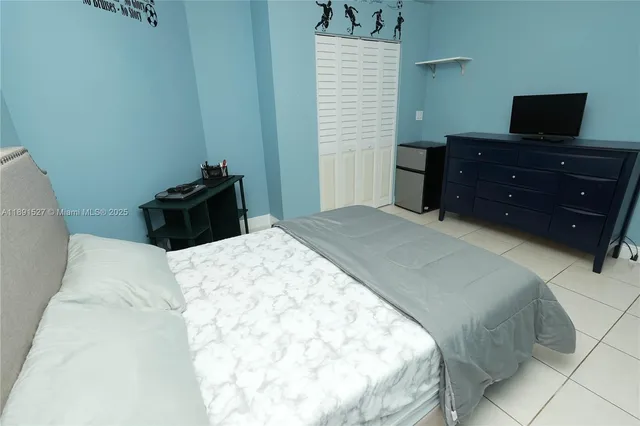 a bedroom with a bed and a television