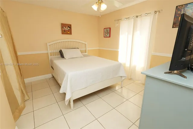 a bedroom with a bed and a flat tv screen on the dresser