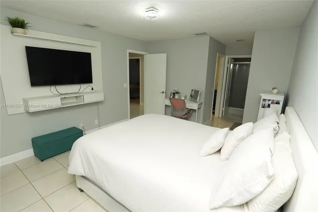 a bedroom with a bed and a flat screen tv