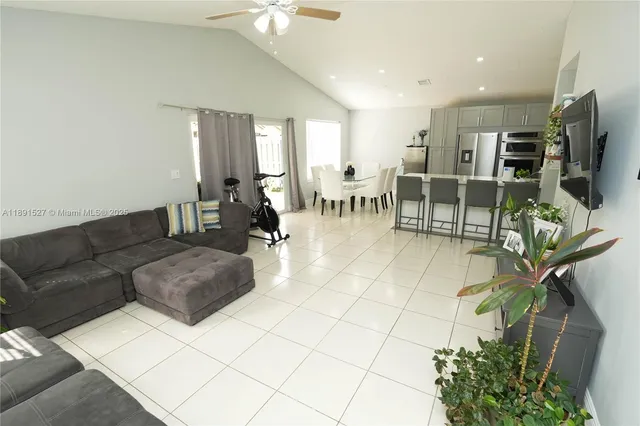 a living room with furniture a flat screen tv and a dining table