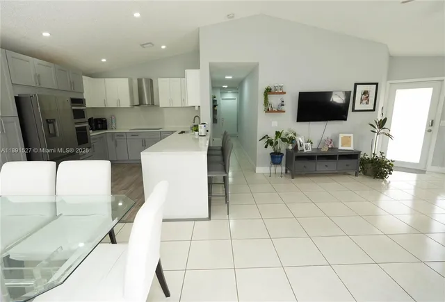 a living room with couches and kitchen view