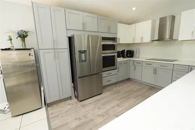 a kitchen with stainless steel appliances a refrigerator sink and cabinets