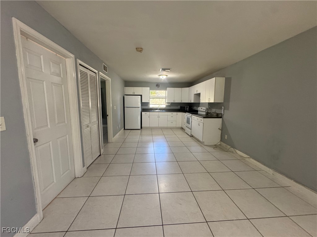 291 16th Street Northeast, Unit 1 Naples, FL 34120 - Photo 7 of 21 a large white kitchen with a stove a sink dishwasher and a refrigerator