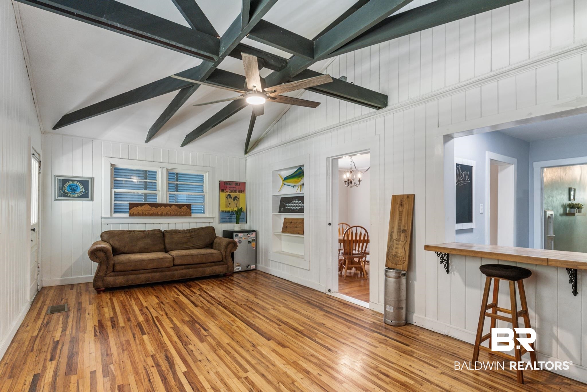 114 Crenshaw Street Mobile, AL 36606 - Photo 22 of 49 Living room featuring lofted ceiling with beams, built in features, wooden walls, ceiling fan with notable chandelier, and hardwood / wood-style flooring
