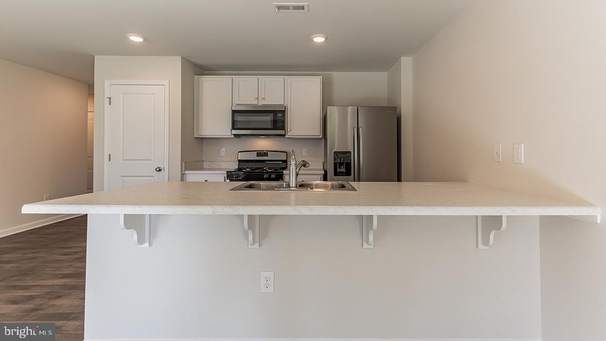 101 Whitman Lane Woodbine, NJ 08270 - Photo 14 of 29 a kitchen with stainless steel appliances a refrigerator and a stove top oven