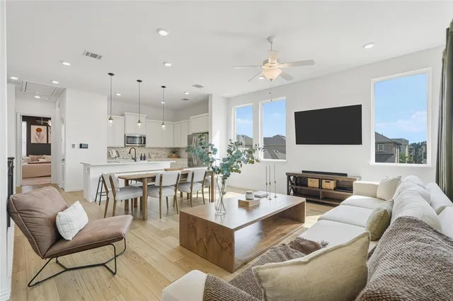 a living room with furniture kitchen view and a flat screen tv