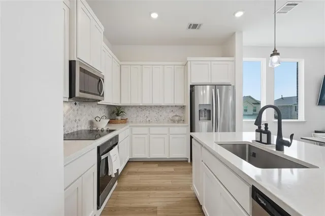 a kitchen with a sink stove and refrigerator