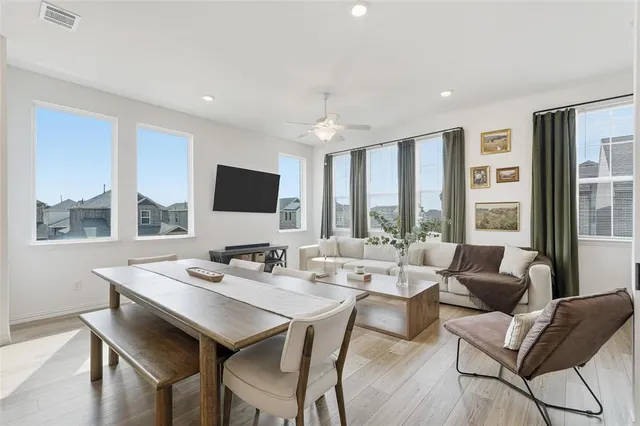 a dining room with furniture a large window and a flat screen tv
