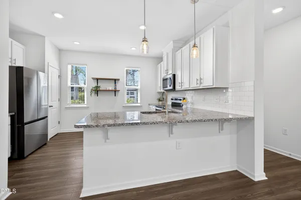 a kitchen with stainless steel appliances granite countertop a sink refrigerator and microwave