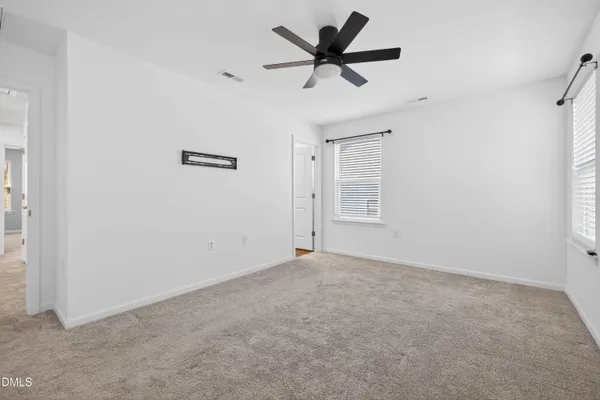 an empty room with a ceiling fan and a window
