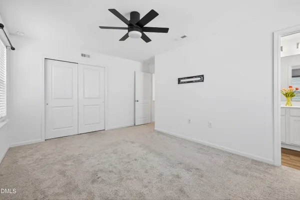 an empty room with a ceiling fan and a window