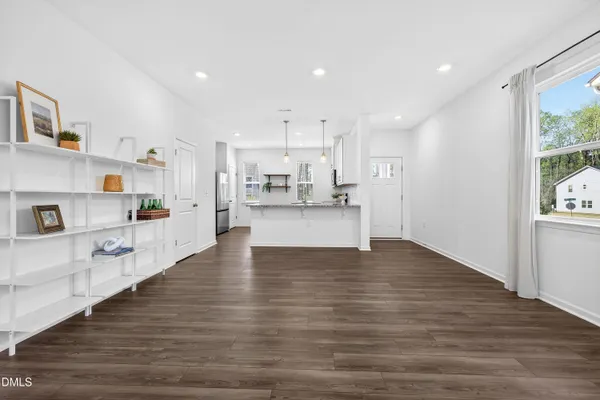 a view of kitchen with kitchen island stainless steel appliances refrigerator stove and wooden floor