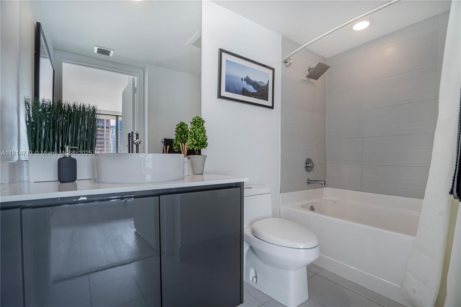 31 Southeast 6th Street, Unit 2205 Miami, FL 33131 - Photo 12 of 25 a bathroom with a sink a toilet and shower