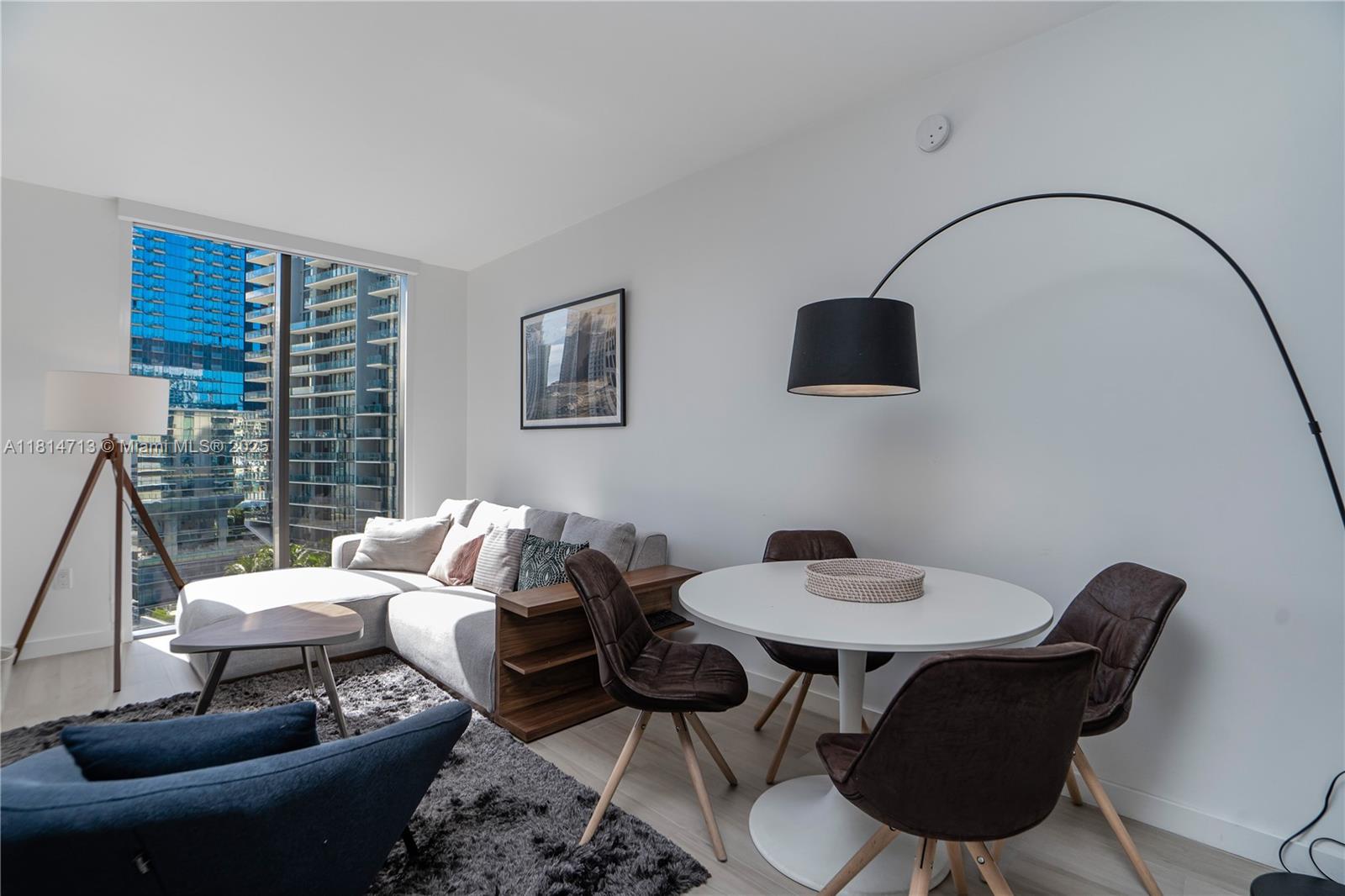 31 Southeast 6th Street, Unit 2205 Miami, FL 33131 - Photo 4 of 25 a living room with furniture and a black and white vase