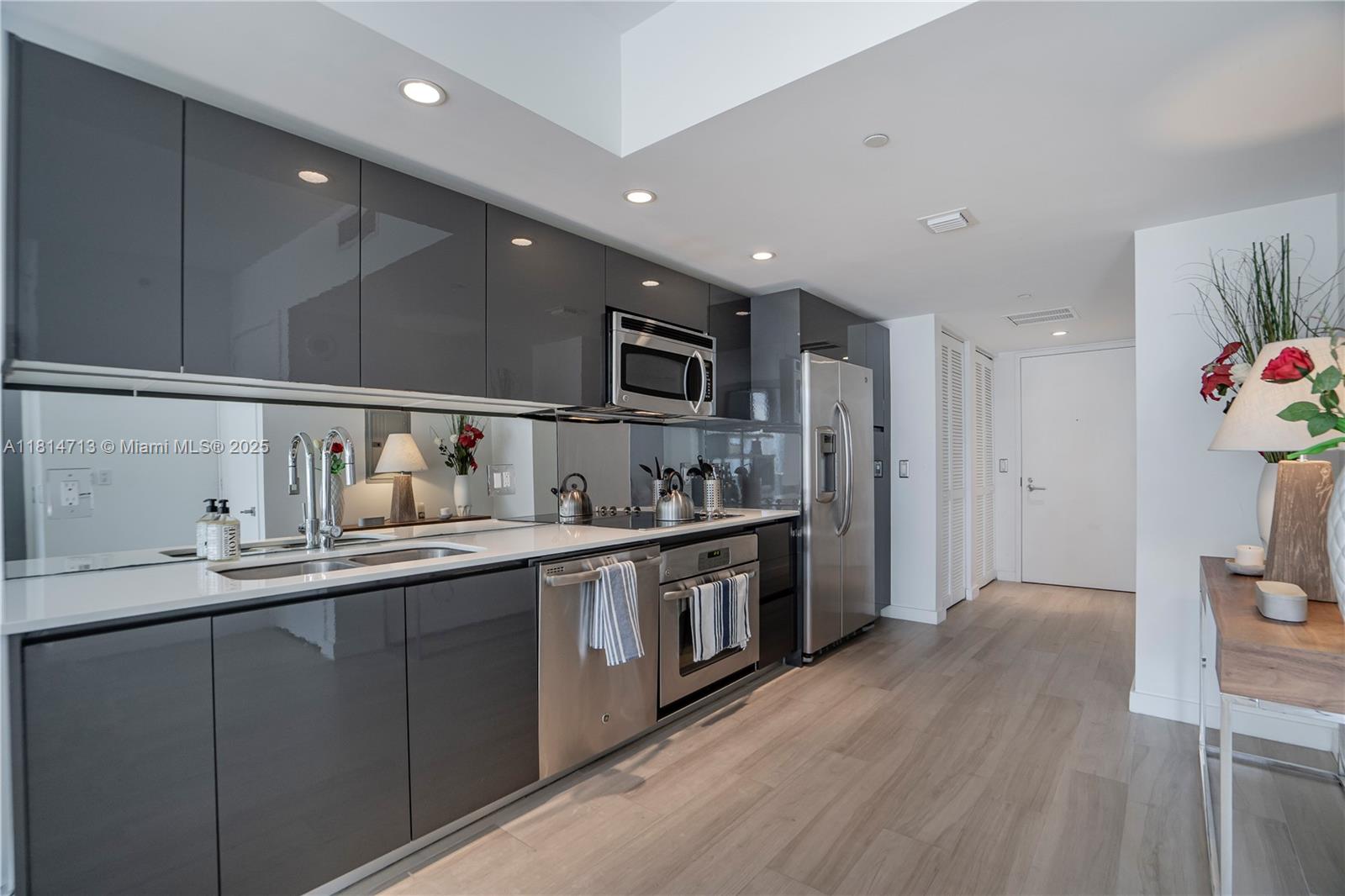 31 Southeast 6th Street, Unit 2205 Miami, FL 33131 - Photo 6 of 25 a kitchen with stainless steel appliances granite countertop a sink stove and refrigerator