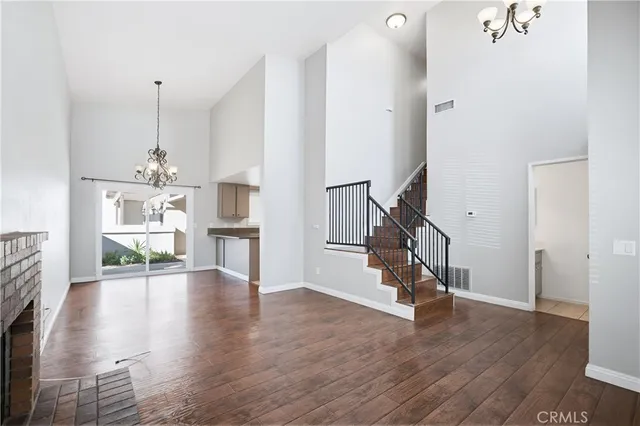 a view of a livingroom with wooden floor and stairs