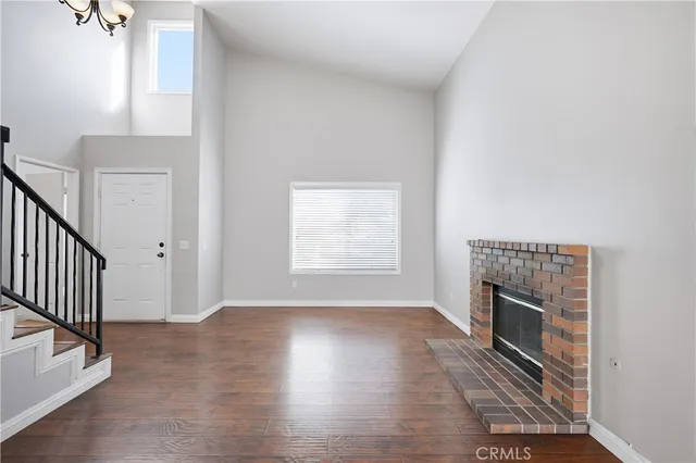 a view of an empty room with a fireplace and a window