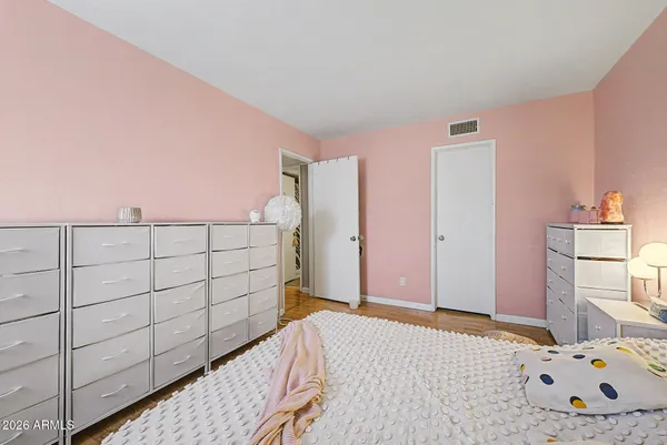a bedroom with a bed and wooden floor