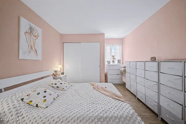 a bedroom with a bed and a lamp on dresser