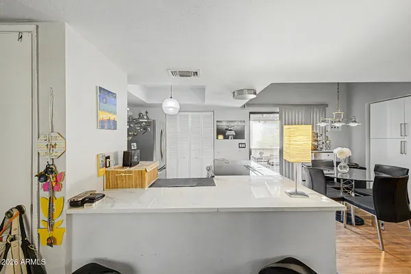 a dining hall with stainless steel appliances kitchen island granite countertop a table and chairs