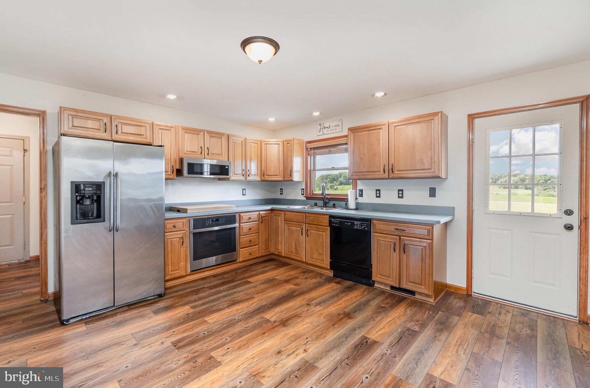 4816 Amos Road White Hall, MD 21161 - Photo 13 of 56 a kitchen with stainless steel appliances granite countertop a refrigerator a sink dishwasher a stove top oven a oven with wooden floor