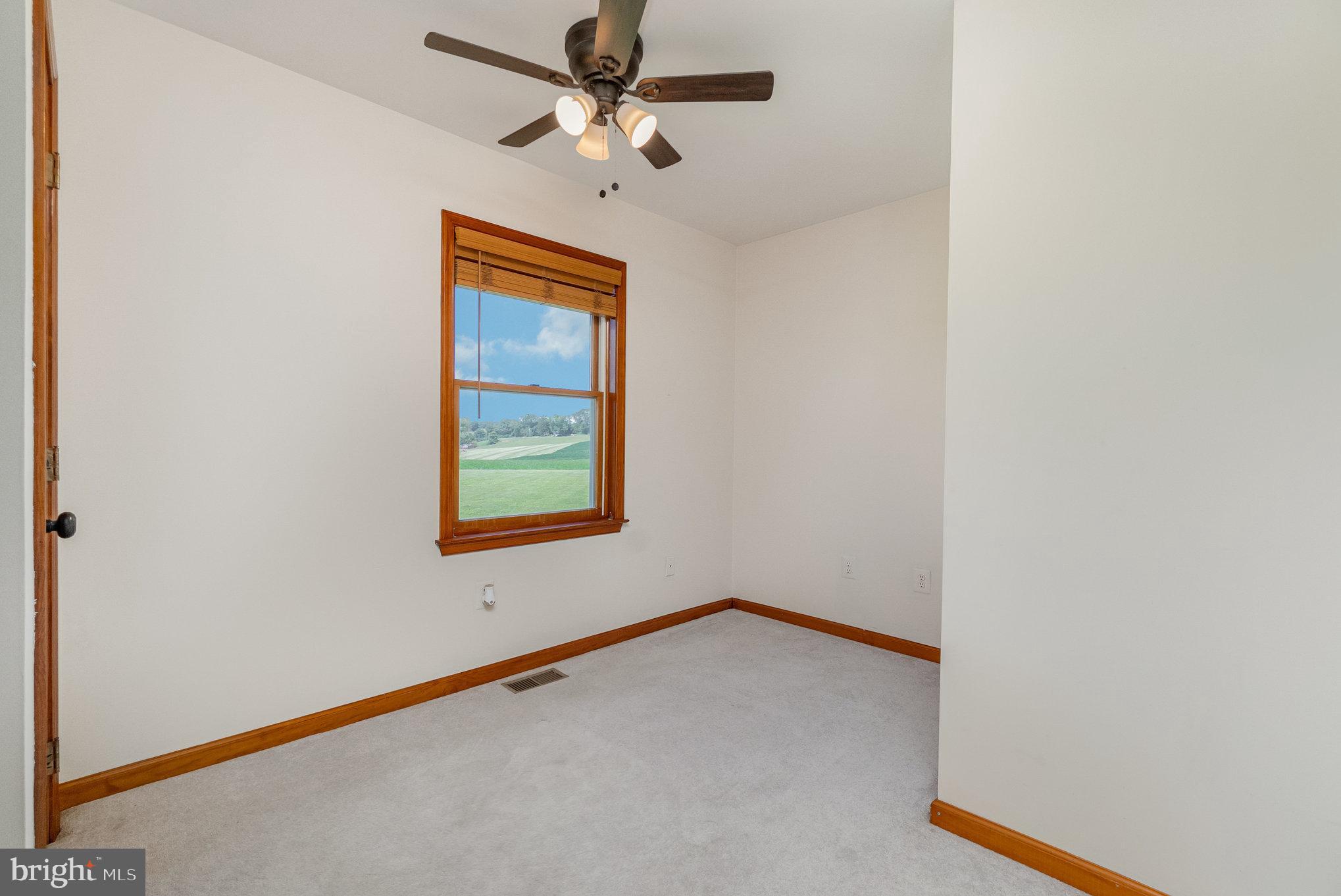 4816 Amos Road White Hall, MD 21161 - Photo 22 of 56 an empty room with windows and fan