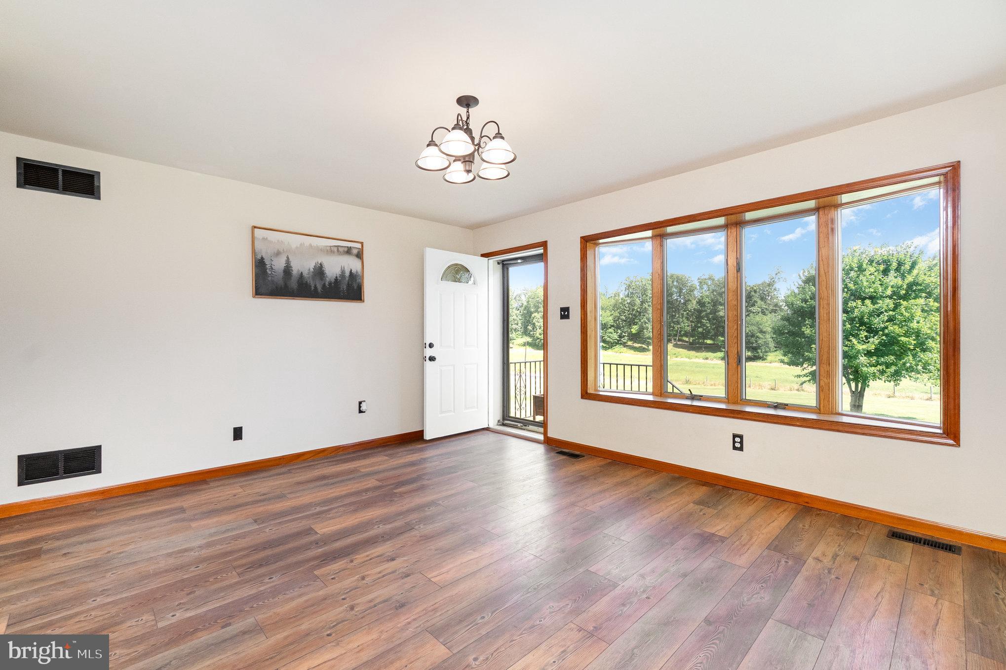 4816 Amos Road White Hall, MD 21161 - Photo 4 of 56 a view of an empty room with wooden floor and a window