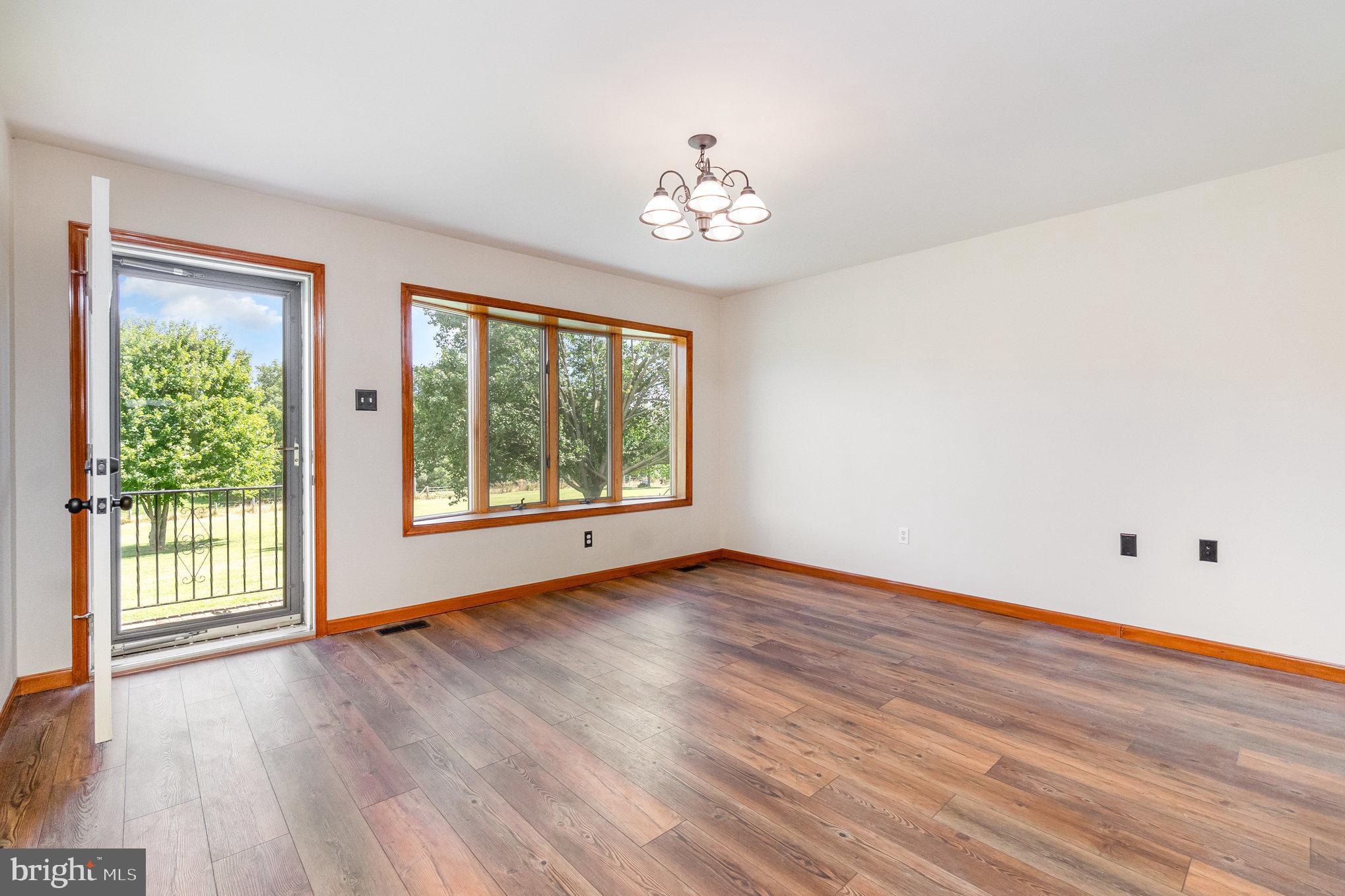4816 Amos Road White Hall, MD 21161 - Photo 5 of 56 a view of an empty room with wooden floor and a window