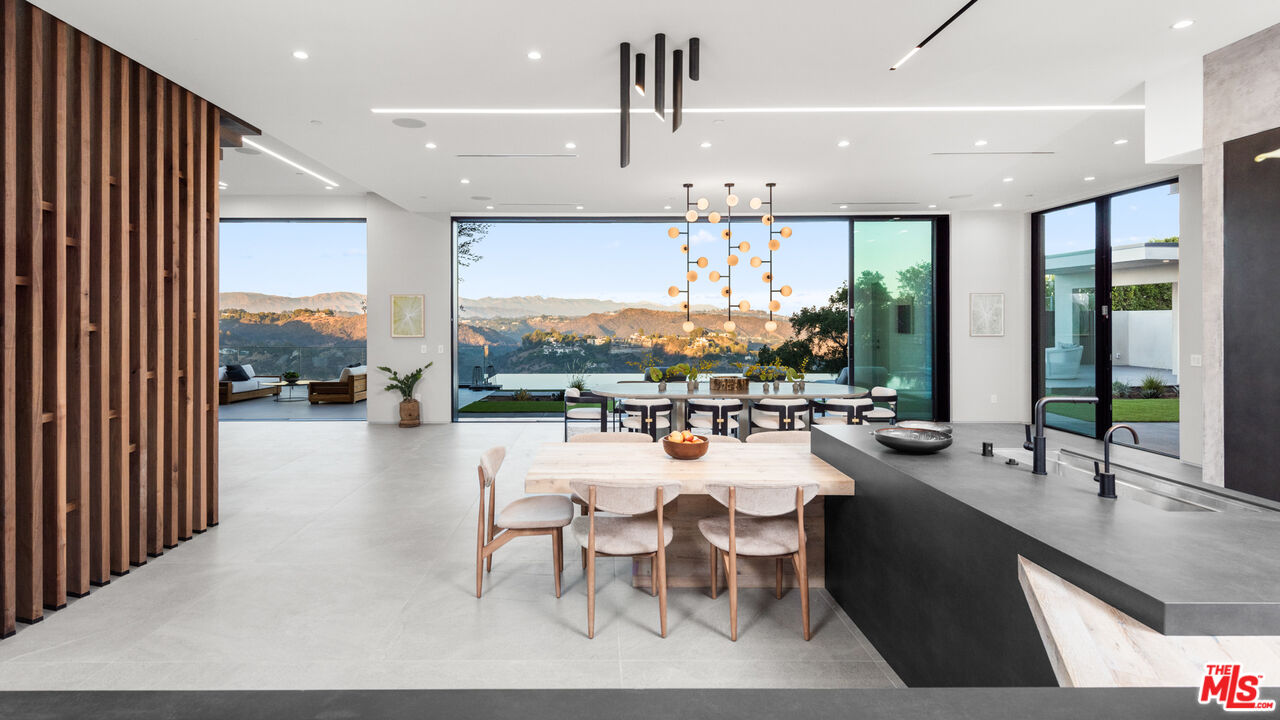 1640 Stradella Road Los Angeles, CA 90077 - Photo 6 of 25 a room with lots of tables a large window and chairs