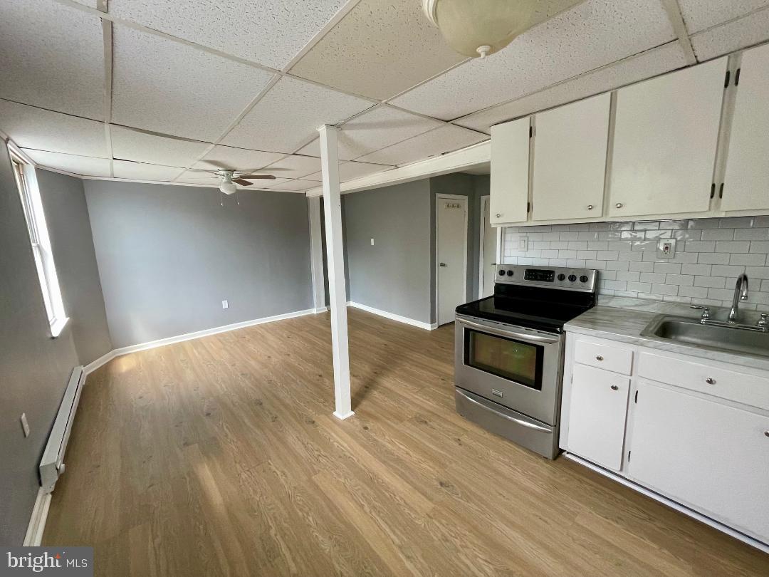 904-906 Main Avenue Croydon, PA 19021 - Photo 28 of 51 a kitchen with granite countertop white cabinets and black appliances with wooden floor