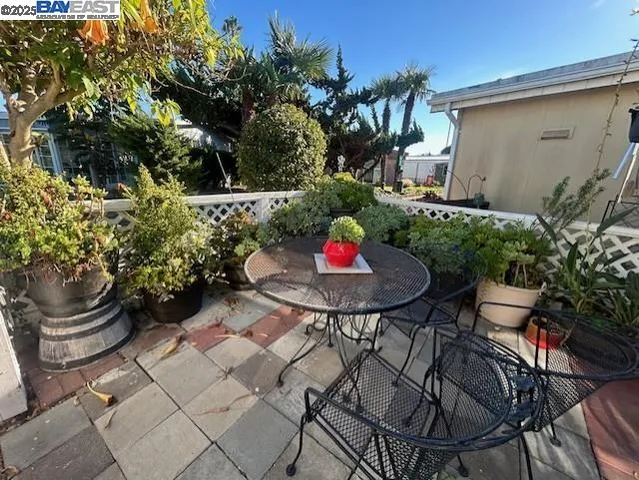 a backyard of a house with table and chairs and potted plants