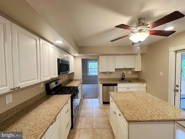 a kitchen with stainless steel appliances granite countertop sink stove and refrigerator
