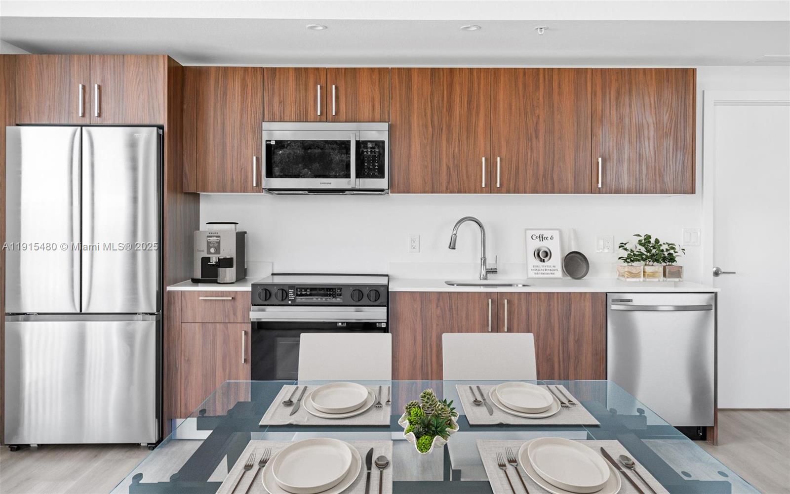 3830 Northwest 11th Street, Unit STUDIO Miami, FL 33126 - Photo 12 of 20 a kitchen with stainless steel appliances a stove a sink a refrigerator a microwave a dining table and chairs