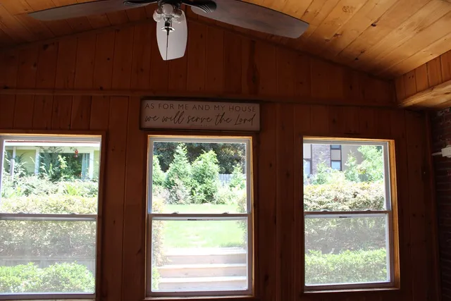 en empty room with windows and ceiling fan