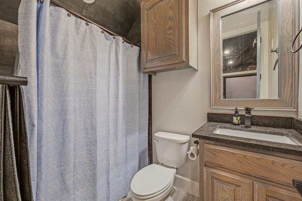 9503 Bellechase Road Granbury, TX 76049 - Photo 31 of 40 a bathroom with a granite countertop sink vanity mirror and toilet