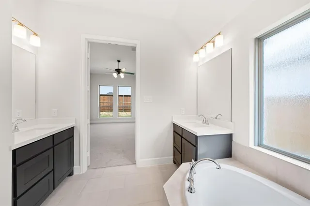 a bathroom with a bathtub a sink a mirror and a shower