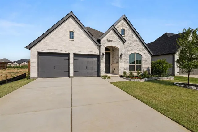 a view of a white house with a yard and large trees