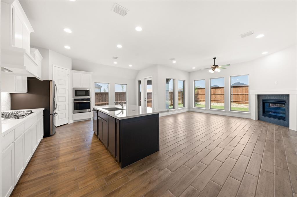 721 Running Iron Trail Mansfield, TX 76063 - Photo 23 of 23 a large kitchen with a center island and wooden floor