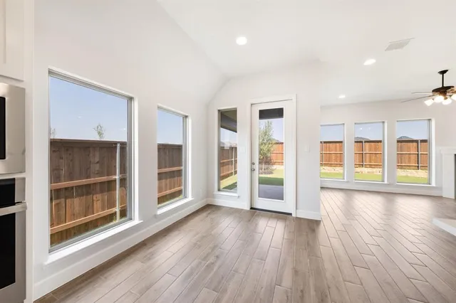 a large kitchen with a center island and wooden floor
