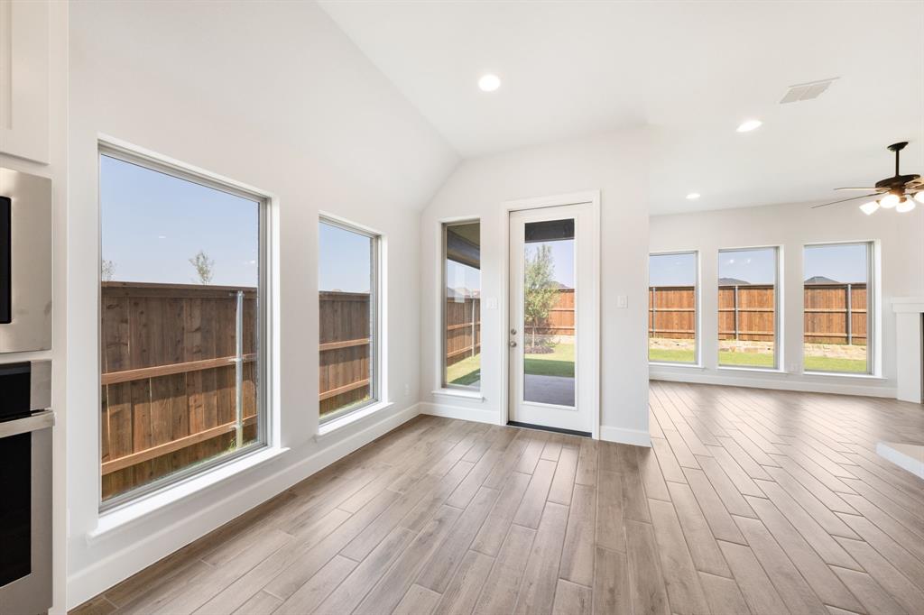 721 Running Iron Trail Mansfield, TX 76063 - Photo 9 of 23 an empty room with wooden floor and windows