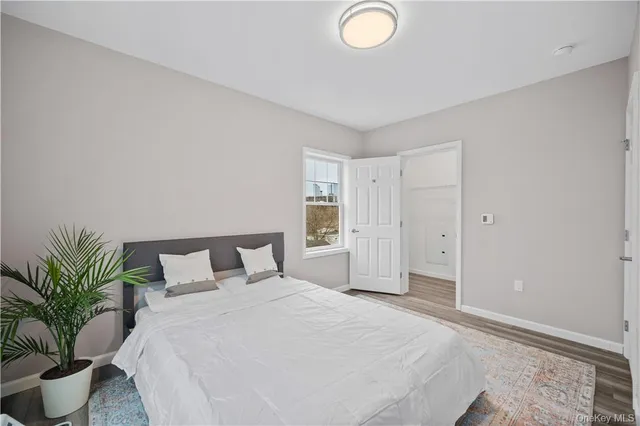 a bedroom with a large bed and a potted plant