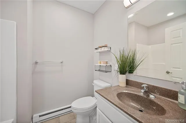 a bathroom with a granite countertop sink toilet and mirror