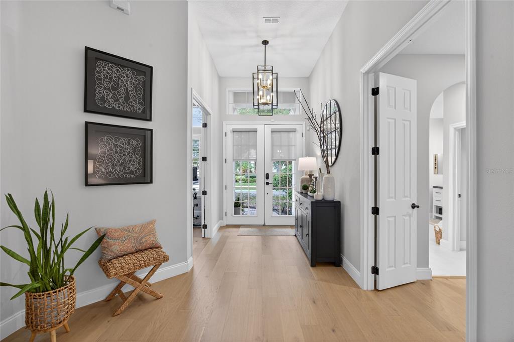 11550 Delwick Drive Windermere, FL 34786 - Photo 12 of 91 a view of a hallway with wooden floor and a chandelier
