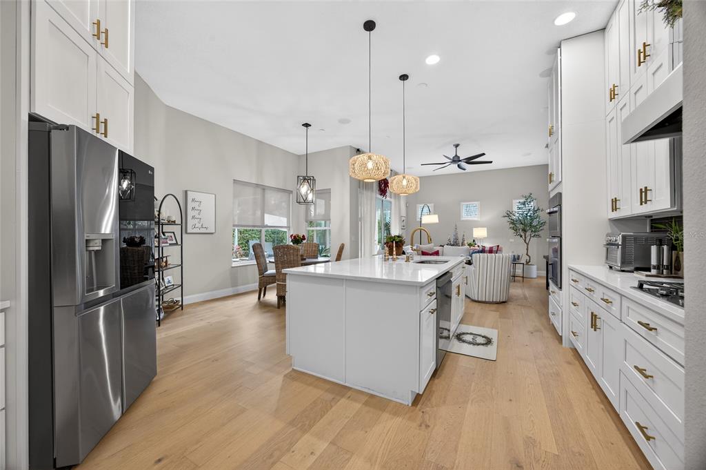 11550 Delwick Drive Windermere, FL 34786 - Photo 35 of 91 a kitchen with stainless steel appliances kitchen island granite countertop a refrigerator a oven a sink and white cabinets with wooden floor