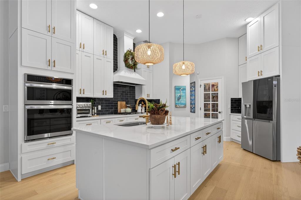 11550 Delwick Drive Windermere, FL 34786 - Photo 37 of 91 a kitchen with stainless steel appliances kitchen island granite countertop a stove a sink and a refrigerator