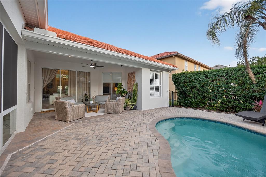 11550 Delwick Drive Windermere, FL 34786 - Photo 63 of 91 a view of a patio with couches chairs potted plants and floor to ceiling window